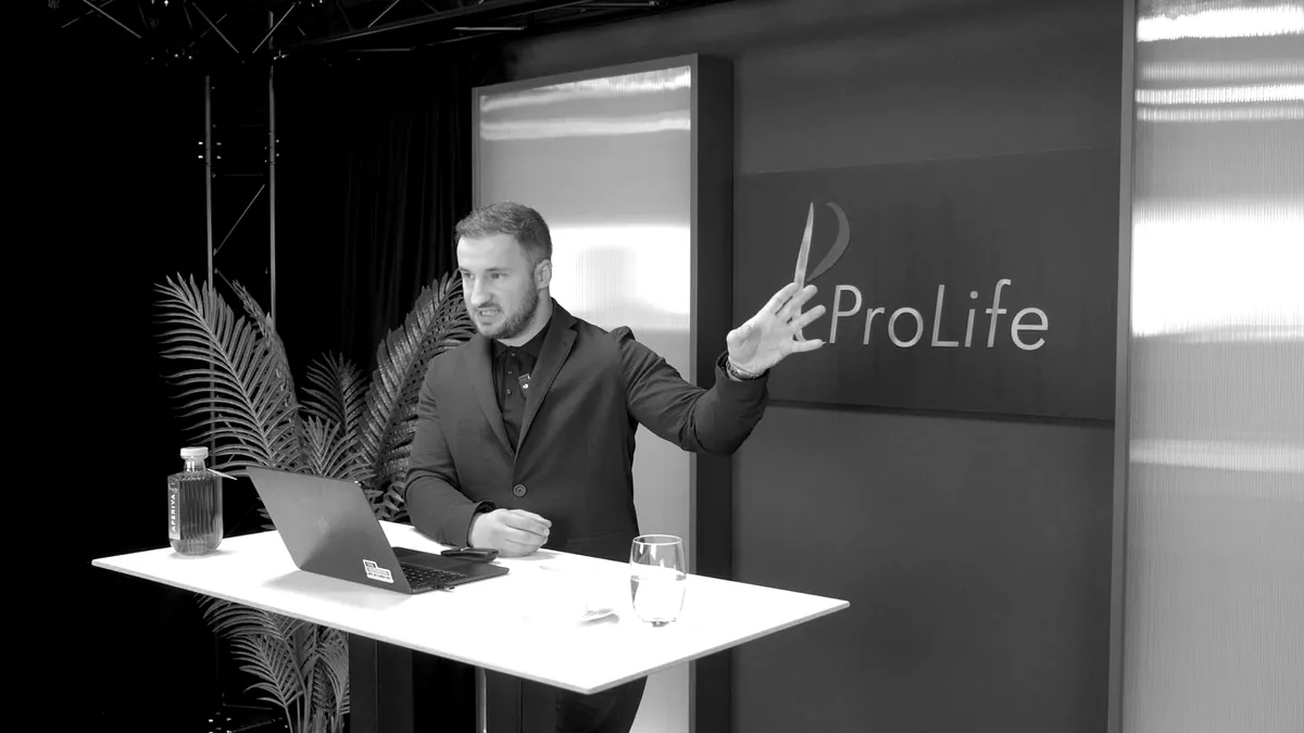 Dardan Morina hält einen Vortrag an einem Stehtisch im Studio