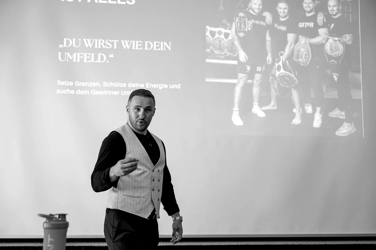 Dardan Morina spricht vor einer Projektionsleinwand